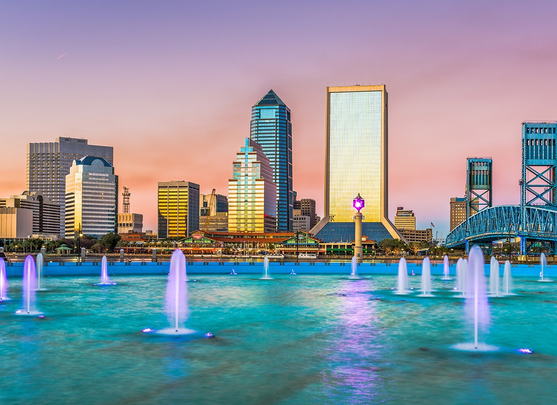 Contact - Aerial View of the Jacksonville, Fl Skyline With a Large Body of Water With Colored Fountains During Sunset